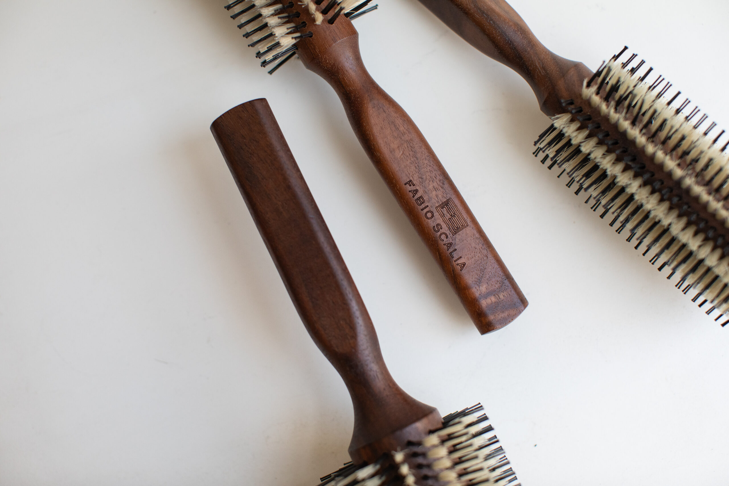 Detail view of La Mora hair brush showing ergonomic walnut wood handle and dual bristles for smooth, frizz-free styling